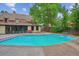 Backyard in-ground pool with diving board, hot tub, concrete deck, mature trees, and home in background at 629 Bellaire St, Denver, CO 80220