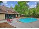 Backyard in-ground pool with diving board, hot tub, concrete deck, mature trees, home, and lounge chairs at 629 Bellaire St, Denver, CO 80220