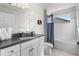 Bright bathroom offers a shower-tub combo and vanity with solid surface countertop at 875 E 78Th Ave # 21, Denver, CO 80229