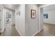 Bright hallway with light wood floors and modern art adorning the neutral colored walls at 875 E 78Th Ave # 21, Denver, CO 80229