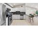 Open kitchen boasts stainless appliances, modern cabinets, and breakfast bar seating with view into Gathering room at 875 E 78Th Ave # 21, Denver, CO 80229