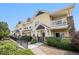 Charming yellow townhome exterior with stone accents and inviting front porch under blue sky at 9434 Ashbury Cir # 204, Parker, CO 80134