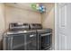 Modern laundry room featuring high-end washer and dryer, plus additional storage on wall shelving at 9434 Ashbury Cir # 204, Parker, CO 80134