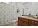 Bathroom featuring a single sink, floral shower curtain, and neutral tile flooring at 1700 N Emerson St # 305, Denver, CO 80218
