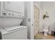 A bathroom with a stacked washer/dryer in the hall and a shower/tub combination with floral shower curtain at 1700 N Emerson St # 305, Denver, CO 80218