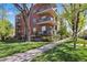 Brick building with multiple balconies, set amidst mature trees and a well-maintained lawn at 1700 N Emerson St # 305, Denver, CO 80218