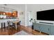 Open-concept living room featuring wood floors, eat-in kitchen, and a modern entertainment center at 1700 N Emerson St # 305, Denver, CO 80218