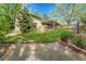 Well-manicured backyard with a wooden fence, walkway and a pergola-covered patio, set against a backdrop of mature trees at 3014 E Fremont Dr, Centennial, CO 80122