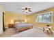 Bright bedroom with a comfortable bed, warm yellow walls, and a window with plantation shutters at 3014 E Fremont Dr, Centennial, CO 80122