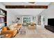 Spacious living room with exposed beams, ample seating, large window, and neutral tones at 3014 E Fremont Dr, Centennial, CO 80122
