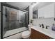 Modern bathroom with a glass shower, a sleek vanity with matte black fixtures, and grey tile at 1742 S Alcott St, Denver, CO 80219