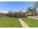 Charming single story brick home featuring a well-maintained front yard and stylish wooden porch at 1742 S Alcott St, Denver, CO 80219