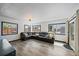 Spacious living room featuring large windows, gray flooring, and leather sectional sofa at 1742 S Alcott St, Denver, CO 80219