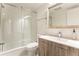 Modern bathroom with tub, glass door and wood vanity at 1050 N Corona St # 206, Denver, CO 80218