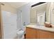 Bright bathroom with a shower over the tub, single sink vanity, and neutral wall colors at 5017 Ceylon St, Denver, CO 80249