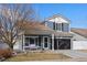 Charming two-story home featuring a well-kept lawn, covered porch, and a two-car garage at 5017 Ceylon St, Denver, CO 80249