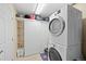 Functional laundry room with stacked washer and dryer and storage shelving at 5017 Ceylon St, Denver, CO 80249