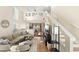 Bright living room featuring hardwood floors, a comfortable sectional sofa, and staircase to a loft at 5017 Ceylon St, Denver, CO 80249