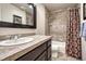 Bathroom with tile backsplash, dark vanity and framed mirror at 3125 Starling Ct, Castle Rock, CO 80109