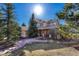 Beautiful home exterior with a well-manicured lawn, mature trees and a stone walkway at 3125 Starling Ct, Castle Rock, CO 80109