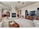 Open living room with stone fireplace, plush carpeting, and seamless flow to the kitchen at 3125 Starling Ct, Castle Rock, CO 80109