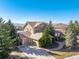 Rear exterior of home featuring a three car garage, large yard and partial mountain views at 3125 Starling Ct, Castle Rock, CO 80109