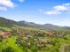 An aerial view showcases the property's beautiful surroundings, including mountains, lush greenery, and a nearby golf course at 5979 Willow Springs Dr, Morrison, CO 80465
