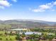 Picturesque aerial view of a community with lakes, golf courses, and rolling hills under a bright blue sky at 5979 Willow Springs Dr, Morrison, CO 80465