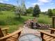 Peaceful backyard with a small water feature, mature trees, and comfortable seating at 5979 Willow Springs Dr, Morrison, CO 80465