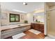 Bright bathroom boasts a soaking tub, dual vanity, wood floors, and walk-in shower at 5979 Willow Springs Dr, Morrison, CO 80465