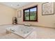 Lovely bathroom with a soaking tub, decorative art, and serene views at 5979 Willow Springs Dr, Morrison, CO 80465