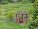 Wooden gazebo nestled among lush greenery and mature trees at 5979 Willow Springs Dr, Morrison, CO 80465