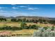 Scenic view overlooking a lush green golf course with rolling hills and blue skies, perfect for outdoor enthusiasts at 5979 Willow Springs Dr, Morrison, CO 80465