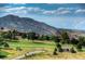 Scenic golf course view with lush green grass and mountain views in the background at 5979 Willow Springs Dr, Morrison, CO 80465
