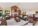 Inviting living room with a cozy fireplace, comfortable seating, and hardwood floors with an open layout to the kitchen at 5979 Willow Springs Dr, Morrison, CO 80465