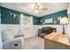 Charming bedroom featuring light gray walls, white trim, a wooden crib, and a cozy chair at 11744 W 71St Pl, Arvada, CO 80004