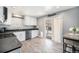 Well-lit kitchen with stainless appliances, white cabinets, and sliding door access to outdoor living space at 11744 W 71St Pl, Arvada, CO 80004