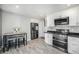Eat-in kitchen featuring white cabinets, stainless steel appliances, and barstool seating at 11744 W 71St Pl, Arvada, CO 80004