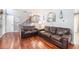 Warm and inviting living room featuring hardwood floors and comfortable brown leather furniture at 11744 W 71St Pl, Arvada, CO 80004