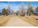 Picturesque park walkway with trees and a small bridge, creating a tranquil outdoor atmosphere at 11744 W 71St Pl, Arvada, CO 80004