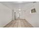Finished basement with neutral tile flooring and a glass paneled door at 4051 S Cherokee St, Englewood, CO 80110