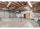 Unfinished basement featuring exposed ceiling beams and a garage door at 4051 S Cherokee St, Englewood, CO 80110