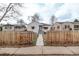 Home exterior features a fenced yard, walkway, and manicured lawn at 4051 S Cherokee St, Englewood, CO 80110