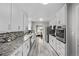 Stylish kitchen with white cabinetry, stainless steel appliances, and granite countertops at 4051 S Cherokee St, Englewood, CO 80110