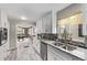 Well-lit kitchen with stainless steel appliances, granite counters, backsplash, and access to dining area at 4051 S Cherokee St, Englewood, CO 80110