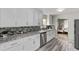 Bright kitchen boasts white cabinets, stainless steel appliances, and stylish backsplash, offering ample counter space at 4051 S Cherokee St, Englewood, CO 80110