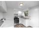Efficient kitchen layout with modern appliances, white cabinets, and adjacent laundry area at 4787 Carr St, Wheat Ridge, CO 80033
