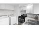 Modern kitchen design with white cabinets, sleek appliances, and a convenient laundry area at 4787 Carr St, Wheat Ridge, CO 80033