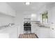 Well-lit kitchen featuring white cabinets, modern appliances, and an adjacent laundry space at 4787 Carr St, Wheat Ridge, CO 80033