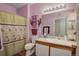 This bathroom features a shower-tub with a decorative curtain, sink with countertop and mirror and tile flooring at 19049 E Warren Dr # 105, Aurora, CO 80013